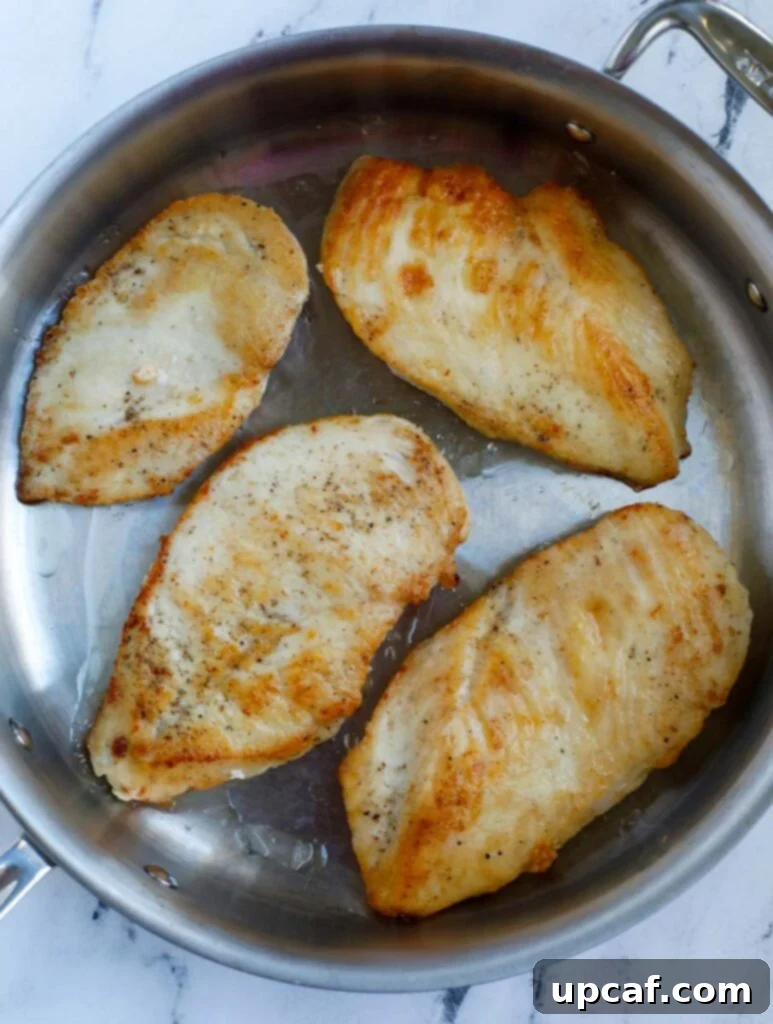 Pan frying chicken breasts until golden brown.