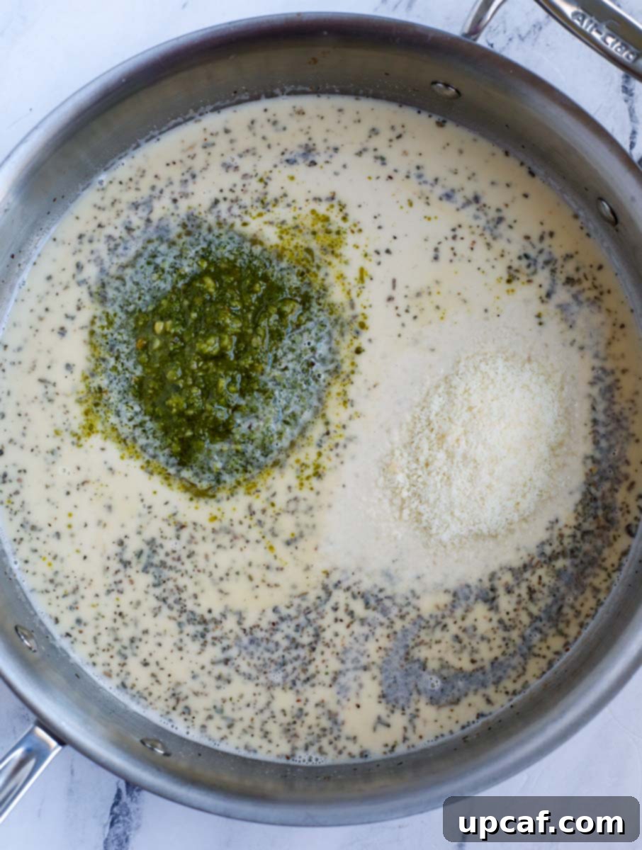 Pesto and cream mixture simmering in a pan.