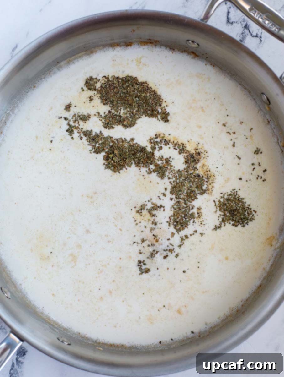 Heavy cream being added to the simmering sauce mixture.