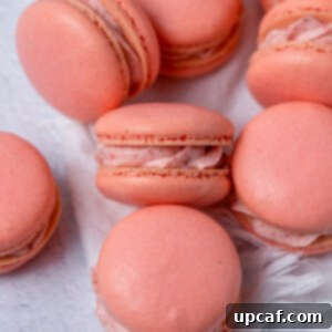 Strawberry Bliss Macarons 8 Close-up of a beautifully assembled strawberry macaron, revealing the creamy strawberry filling and delicate shell.