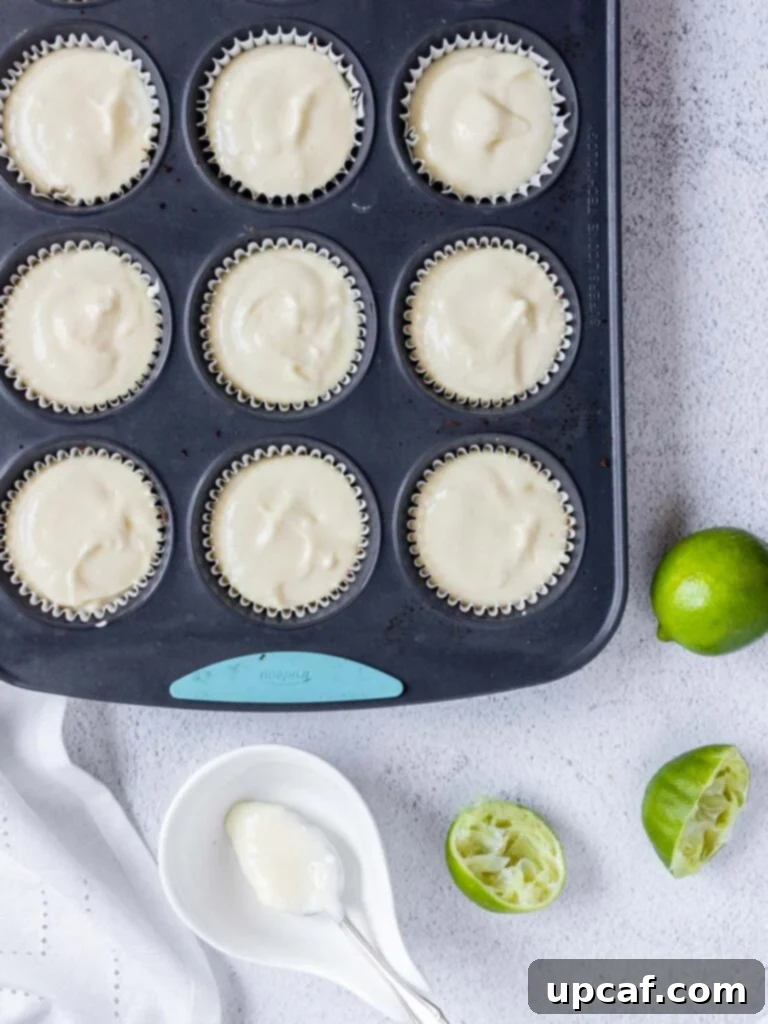 Zesty Key Lime Cheesecake Bites 4 cheesecake filling in a muffin tin pan lined with cupcake holders