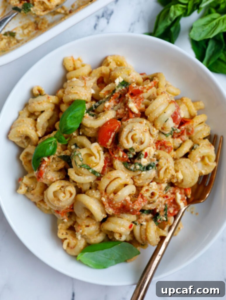 Golden Feta Pasta Bake 2 Overhead photo of a baked feta pasta in a bowl, garnished with fresh basil.