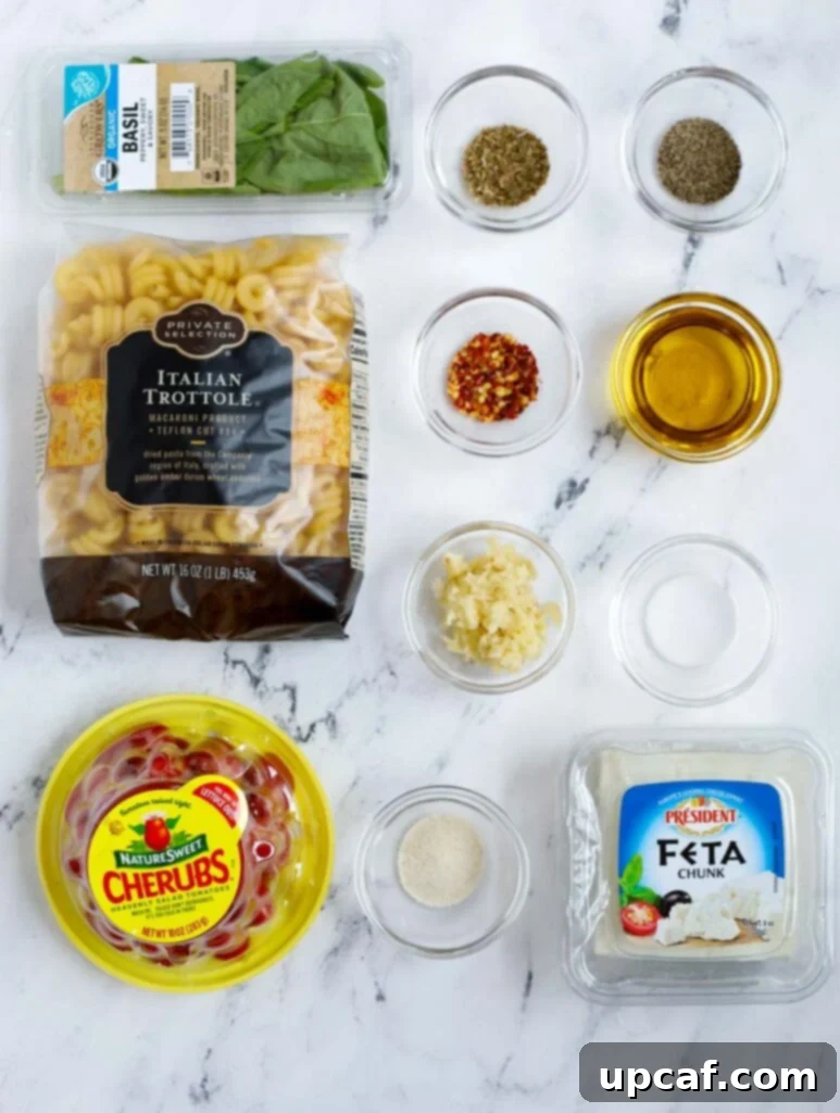 Golden Feta Pasta Bake 3 Ingredients needed for a baked feta pasta, including fresh tomatoes, block of feta, and herbs.