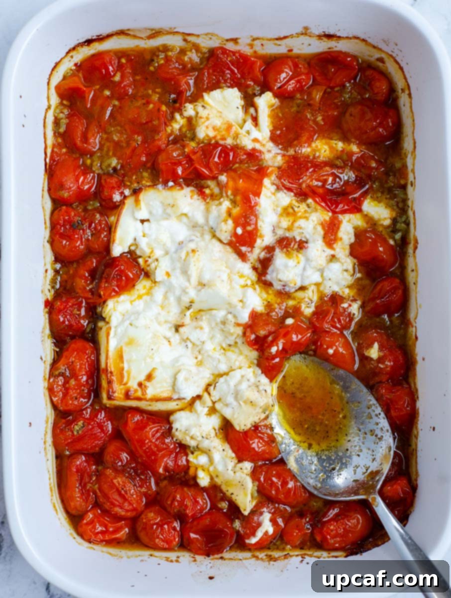 Golden Feta Pasta Bake 6 Crushing the melted feta and blistered tomatoes in a baking dish to form a sauce.