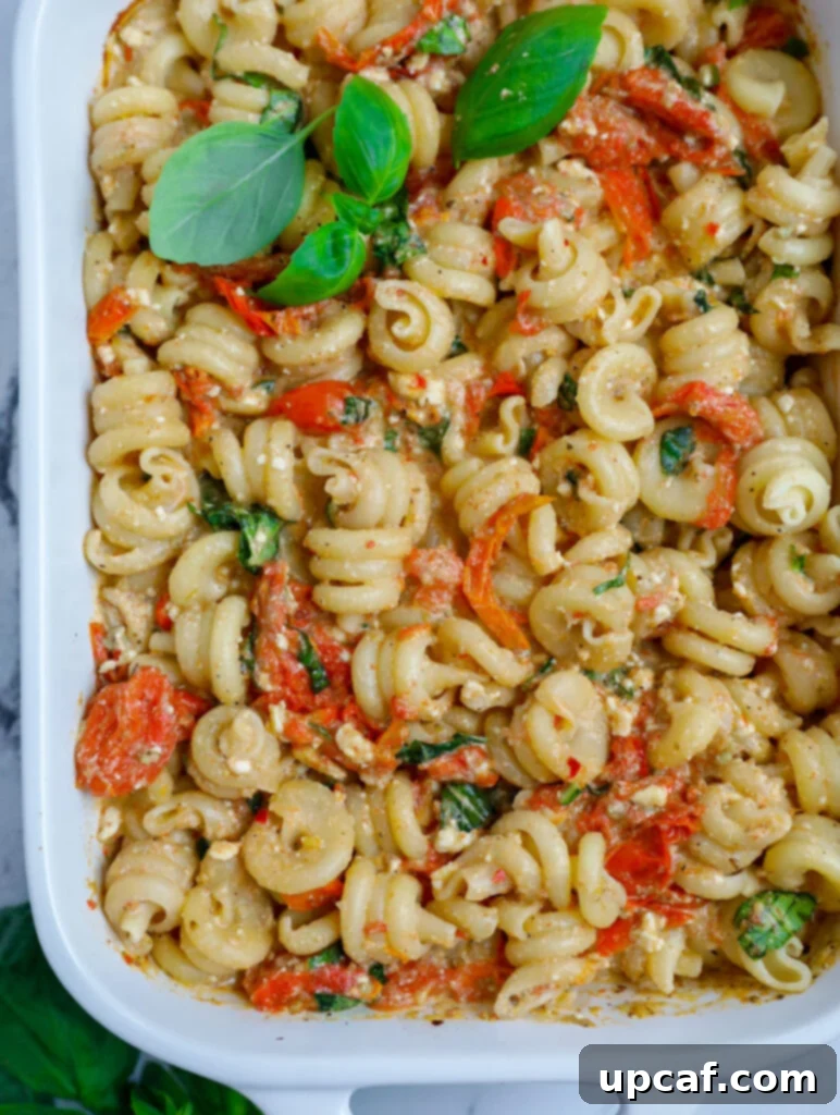 Golden Feta Pasta Bake 9 Baked cheese pasta in a casserole dish garnished with fresh basil.