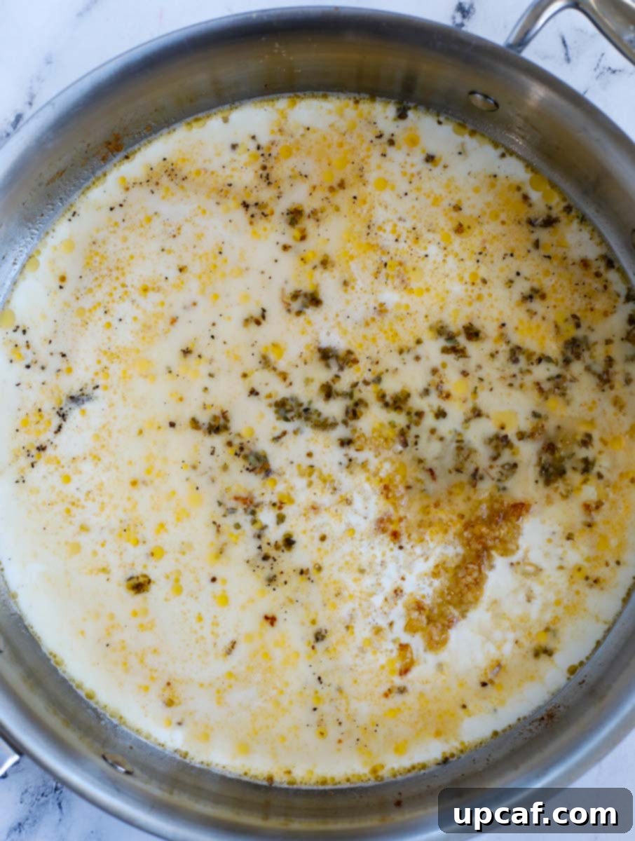 Various ingredients for the Caesar sauce simmering together in a skillet, creating a rich aroma.