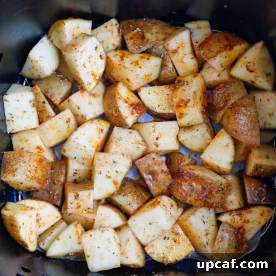 Potatoes in an air fryer basket before cooking.