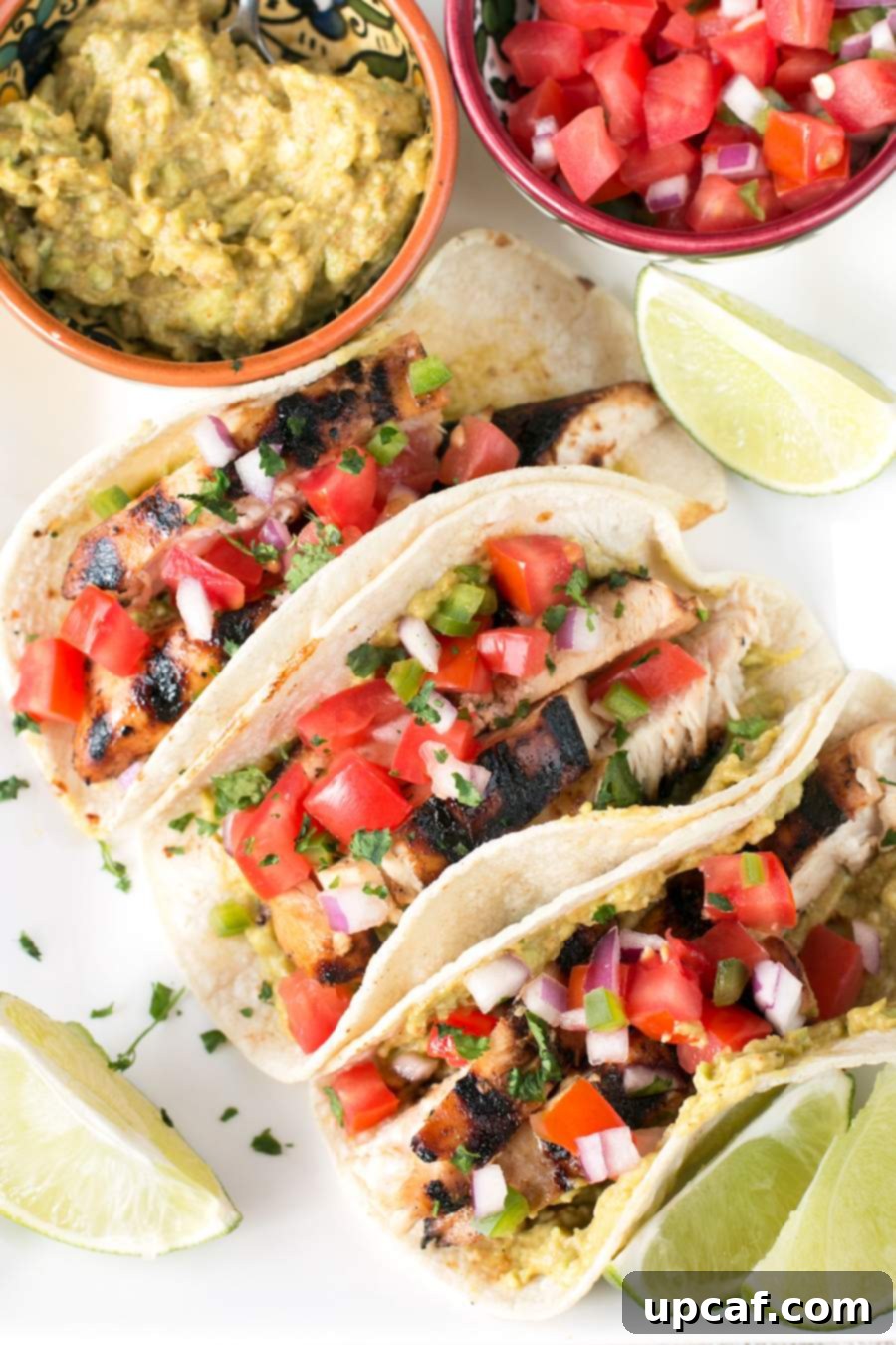 Fiesta Chicken Tacos 2 Flavorful Mexican Chicken Tacos served alongside fresh guacamole and pico de gallo