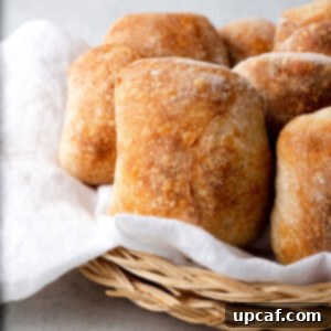 A basket of freshly baked ciabatta rolls, warm and ready to serve.