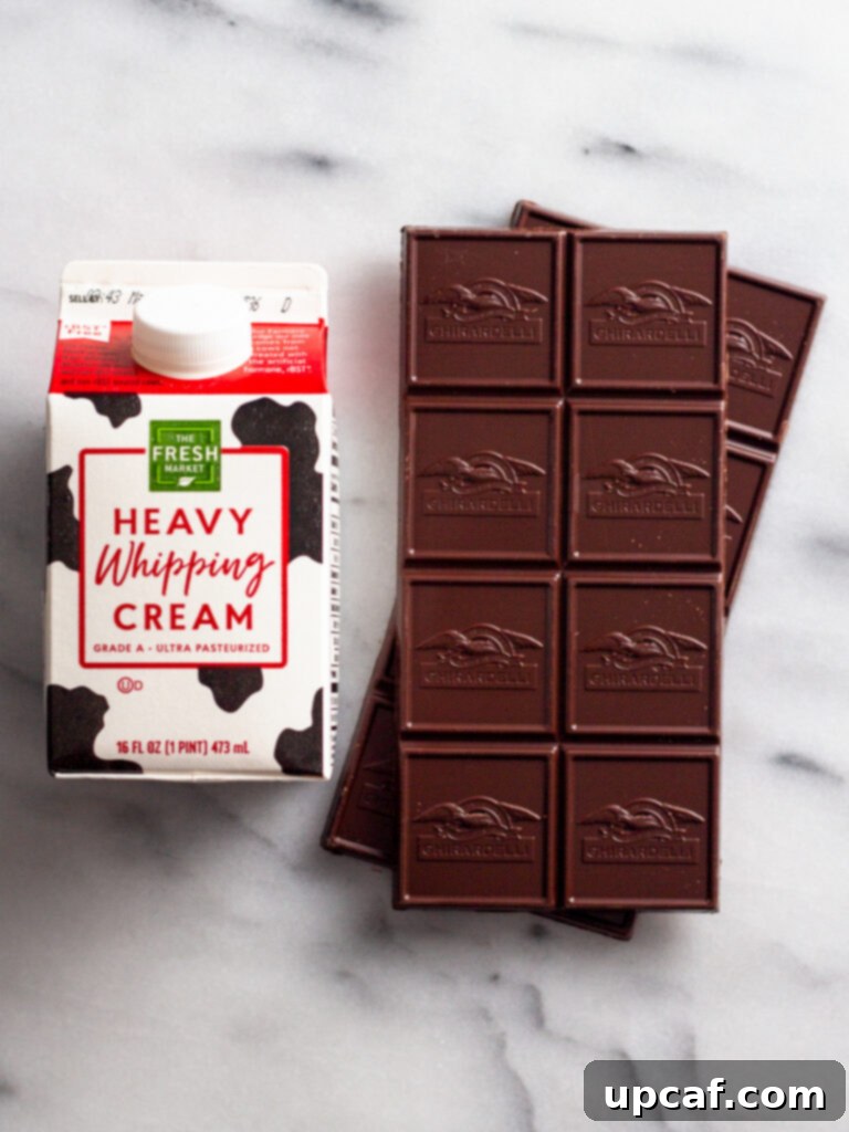 Overhead shot of premium semi-sweet chocolate chunks and rich heavy cream, the two simple ingredients for homemade ganache.