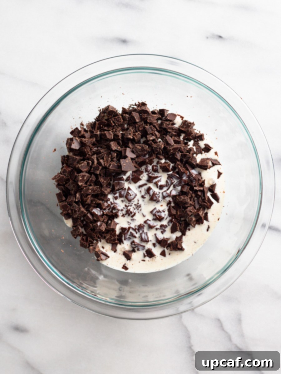 Freshly chopped chocolate and rich heavy cream combined in a bowl, awaiting the gentle stirring process to transform into ganache.