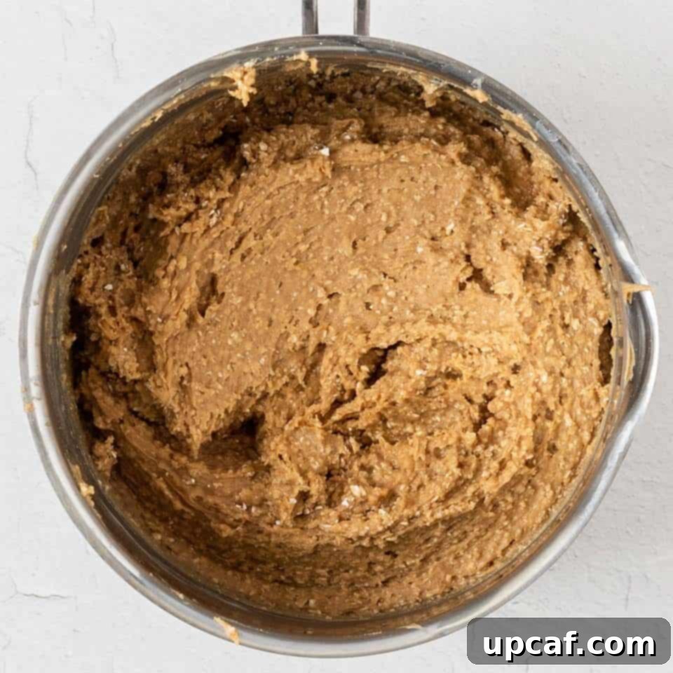 The peanut butter and maple syrup mixture being heated in a pot on the stovetop.