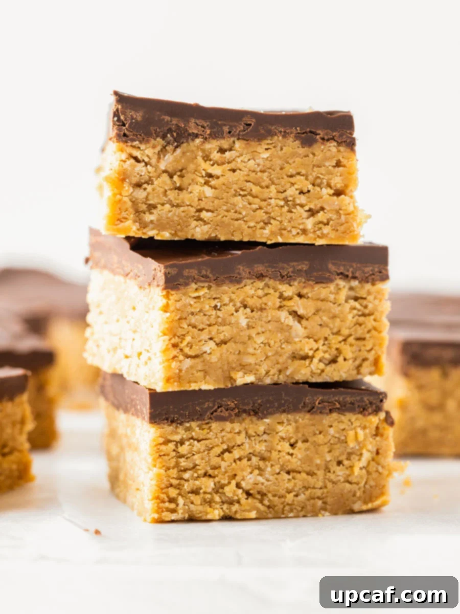 Three chocolate peanut butter oatmeal bars stacked on top of each other, ready to eat.