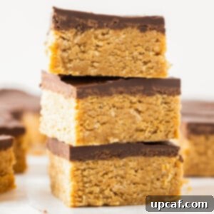 Three chocolate peanut butter oatmeal bars stacked on top of each other.