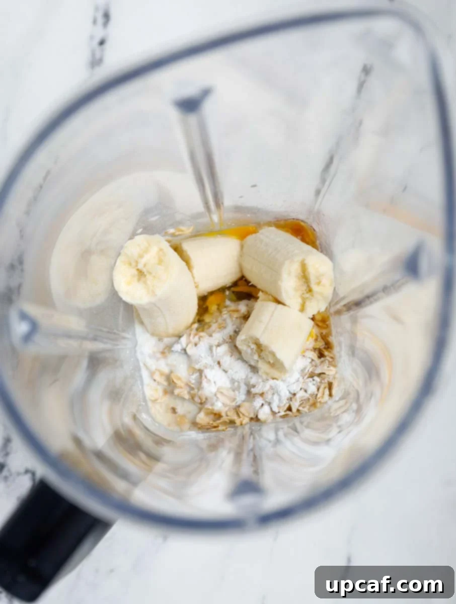 Ingredients for chocolate chip banana baked oats being added to a blender.