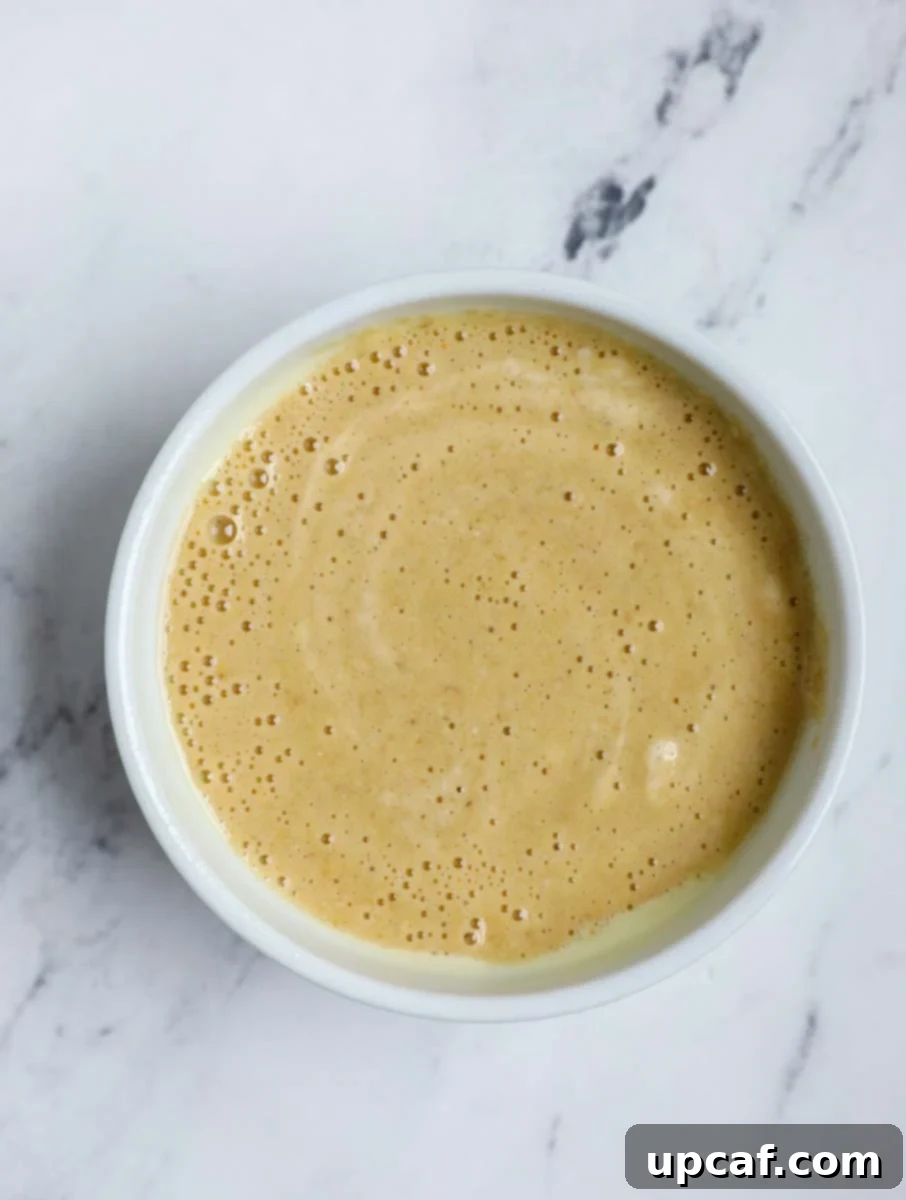 Banana baked oats batter being poured into a ramekin.