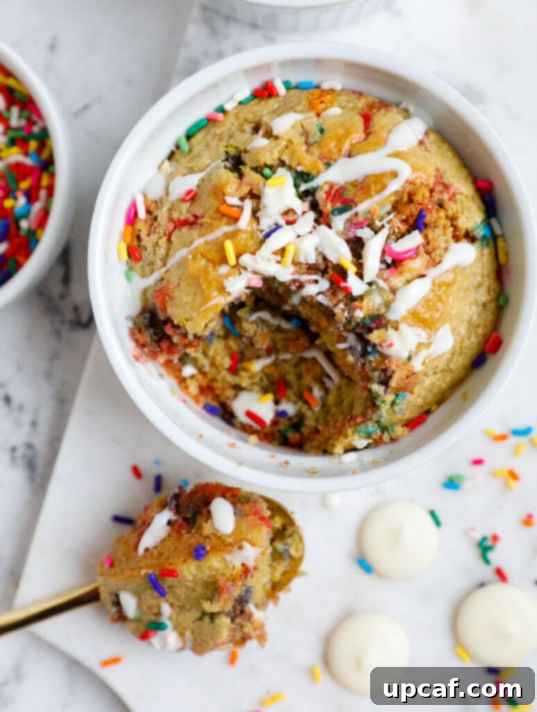 Baked funfetti oat cake with a spoonful scooped out, revealing its moist interior.
