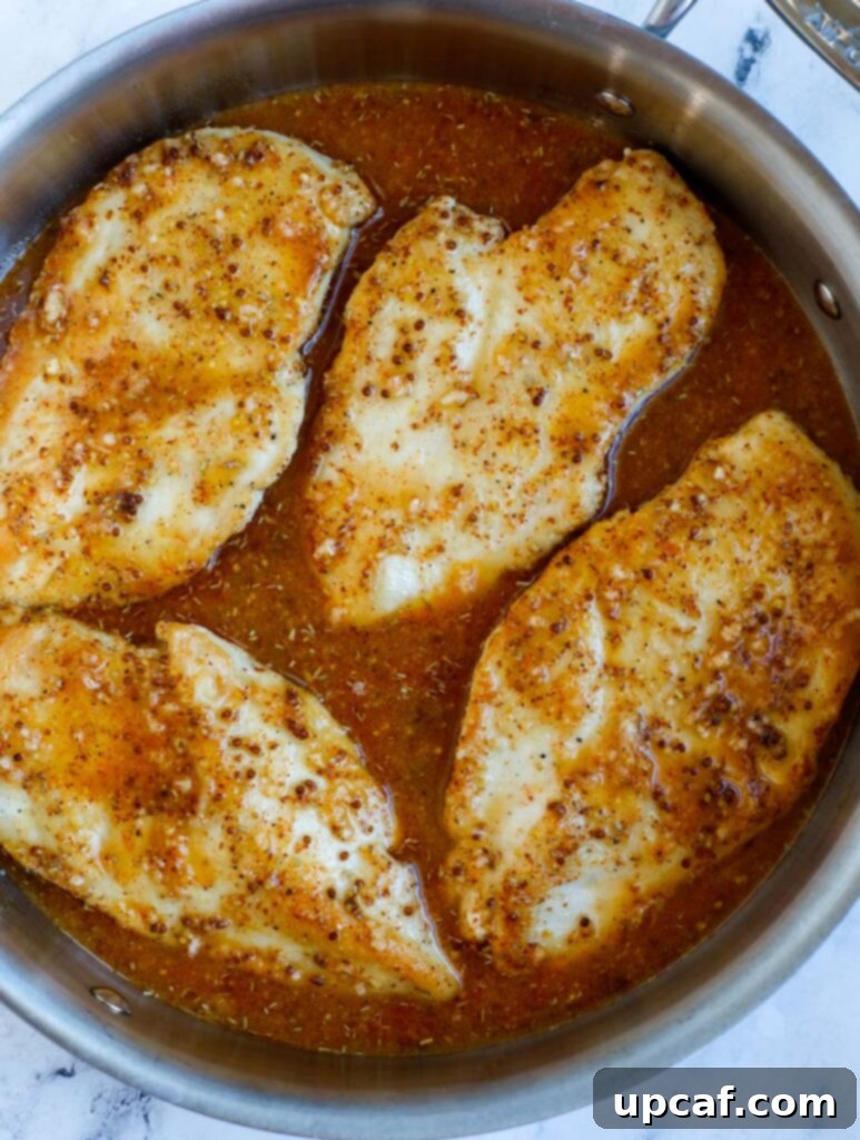 Adding chicken breasts to honey mustard sauce.