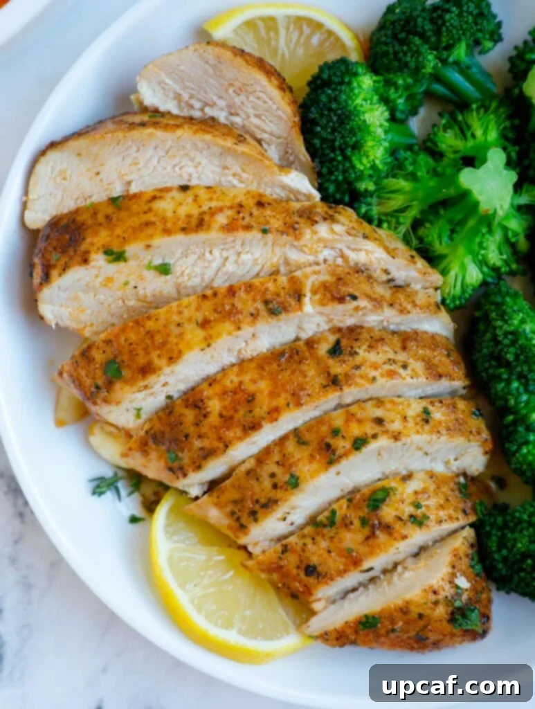 Sliced chicken breast on a plate, showcasing its juicy interior.