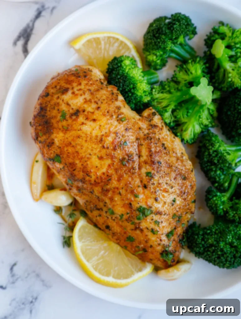 Close up of a chicken breasts beside vibrant broccoli florets, showcasing a healthy meal.