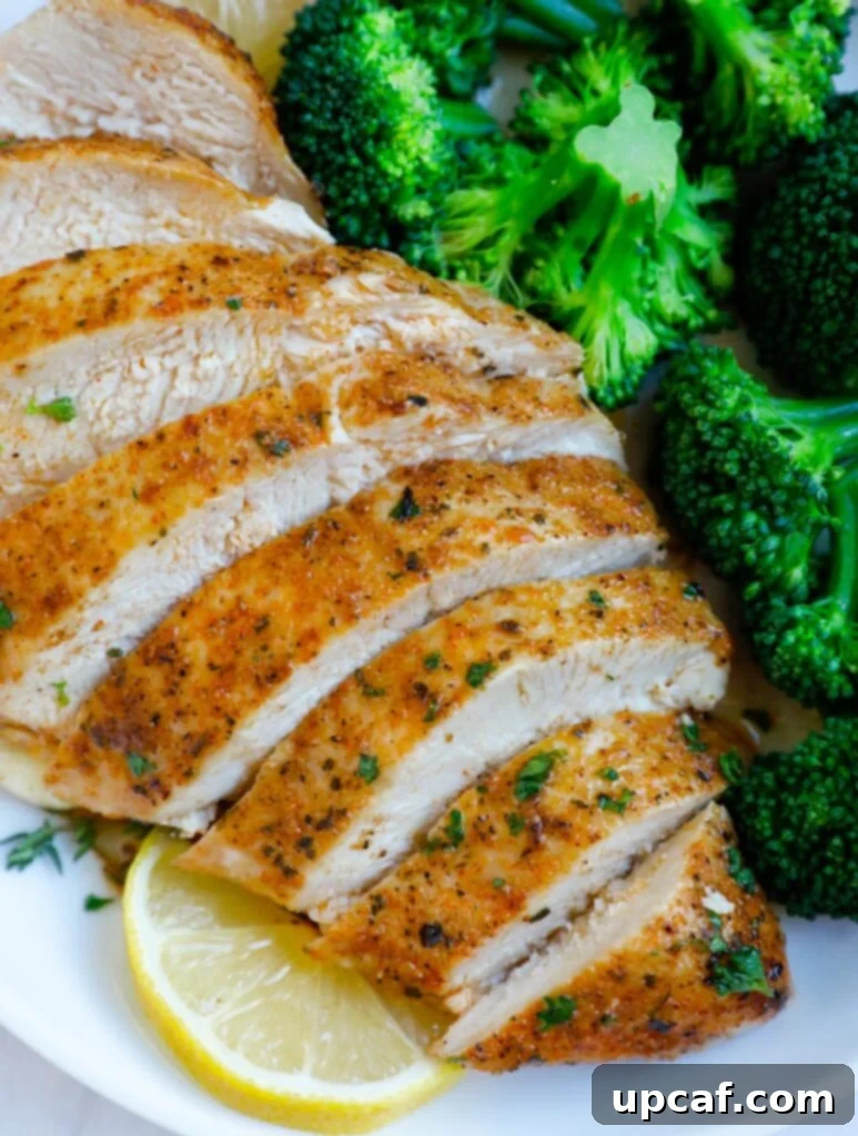 Close up of perfectly sliced baked chicken breasts, revealing the tender meat.