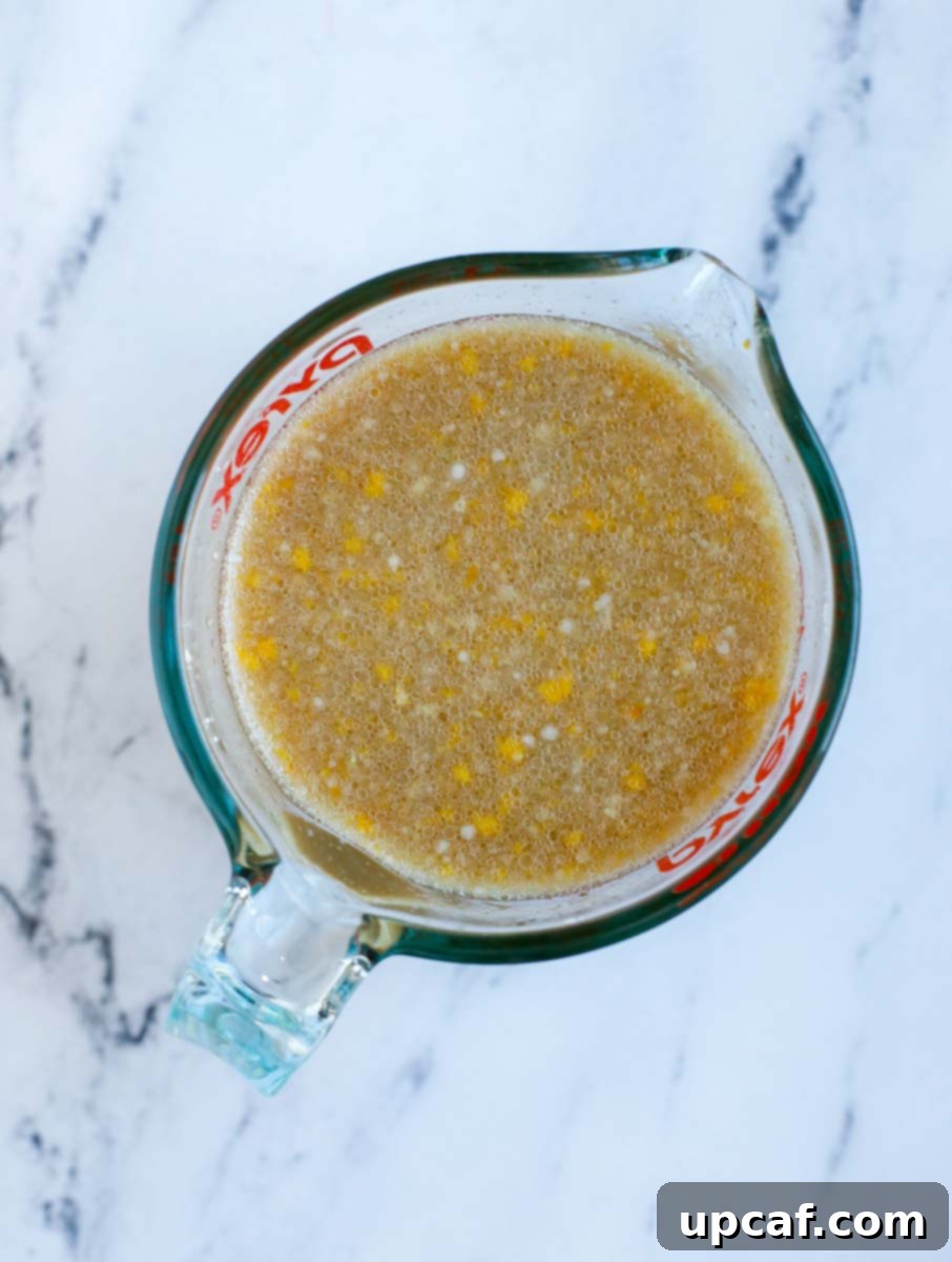 Wholesome Orange Chicken 6 Mixing together all the orange chicken sauce ingredients in a clear measuring cup.