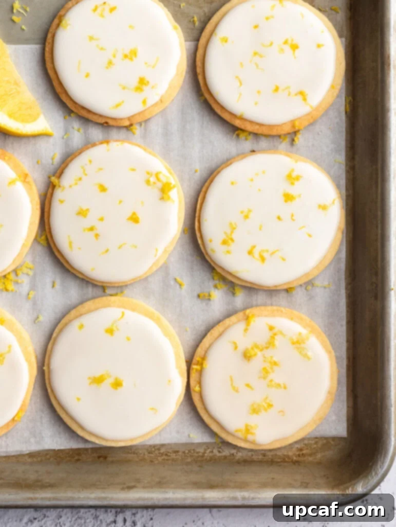 Tangy Lemon Glazed Shortbread 12 A full baking sheet covered with a fresh batch of lemon shortbread cookies, some already adorned with a delicate lemon icing, presenting a tempting array of homemade treats.