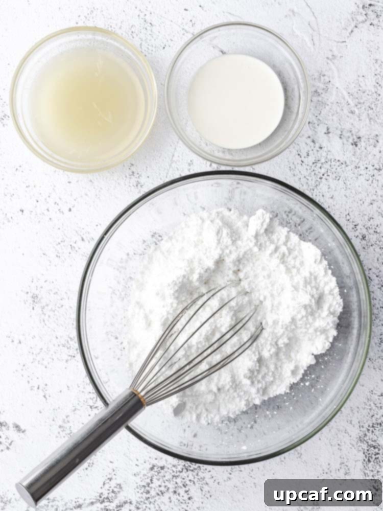 Tangy Lemon Glazed Shortbread 5 A top-down shot of the ingredients specifically for the lemon icing, including powdered sugar, a lemon, and a small container of heavy cream, set against a simple backdrop.