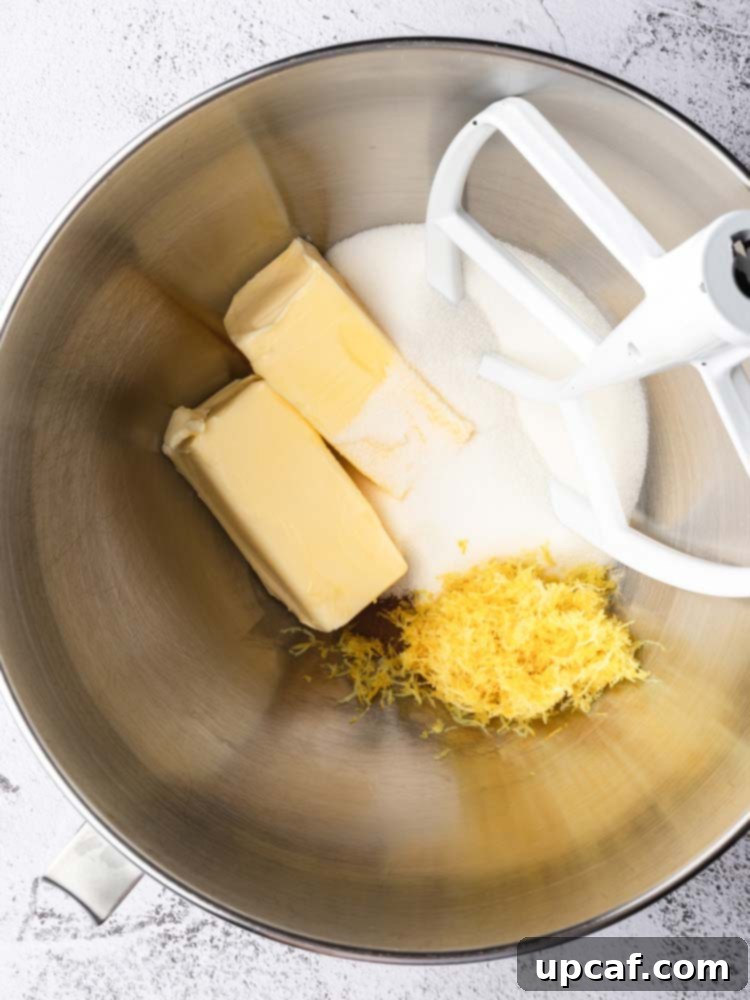 Tangy Lemon Glazed Shortbread 6 Close-up shot of butter, powdered sugar, and lemon zest creaming together in a stand mixer bowl with the paddle attachment, showing the fluffy texture forming.