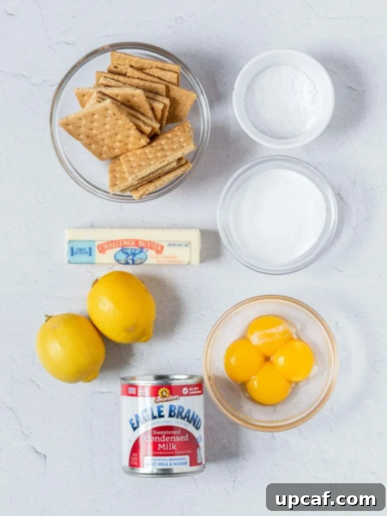 A top-down shot displaying all the simple ingredients required to make a creamy lemon pie, neatly arranged in separate bowls.