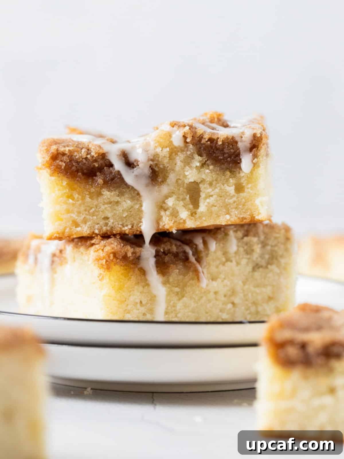 two pieces of Cinnamon Streusel Cake stacked on a white plate