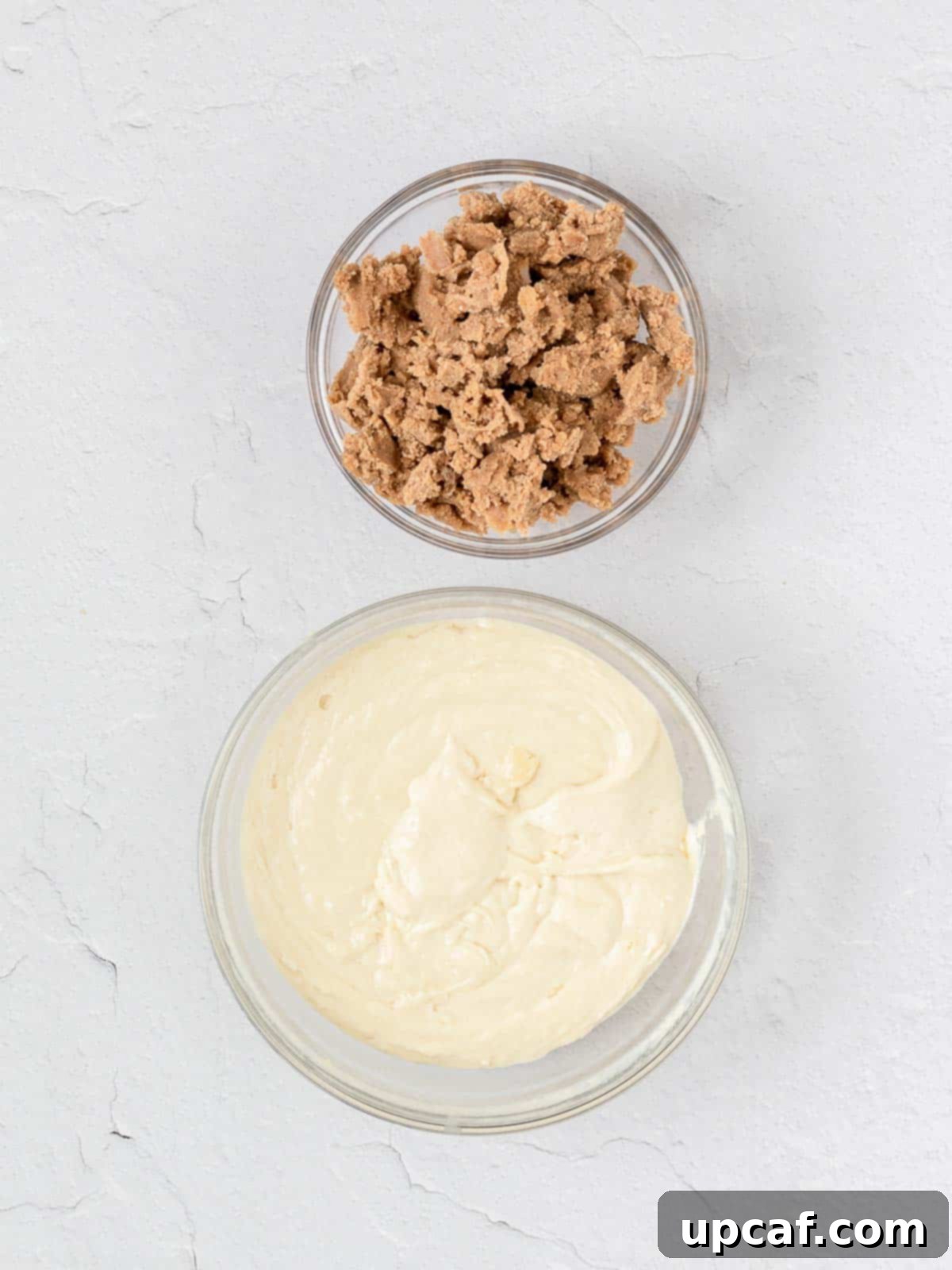 cake batter ready in a bowl next to uncooked streusels mixture