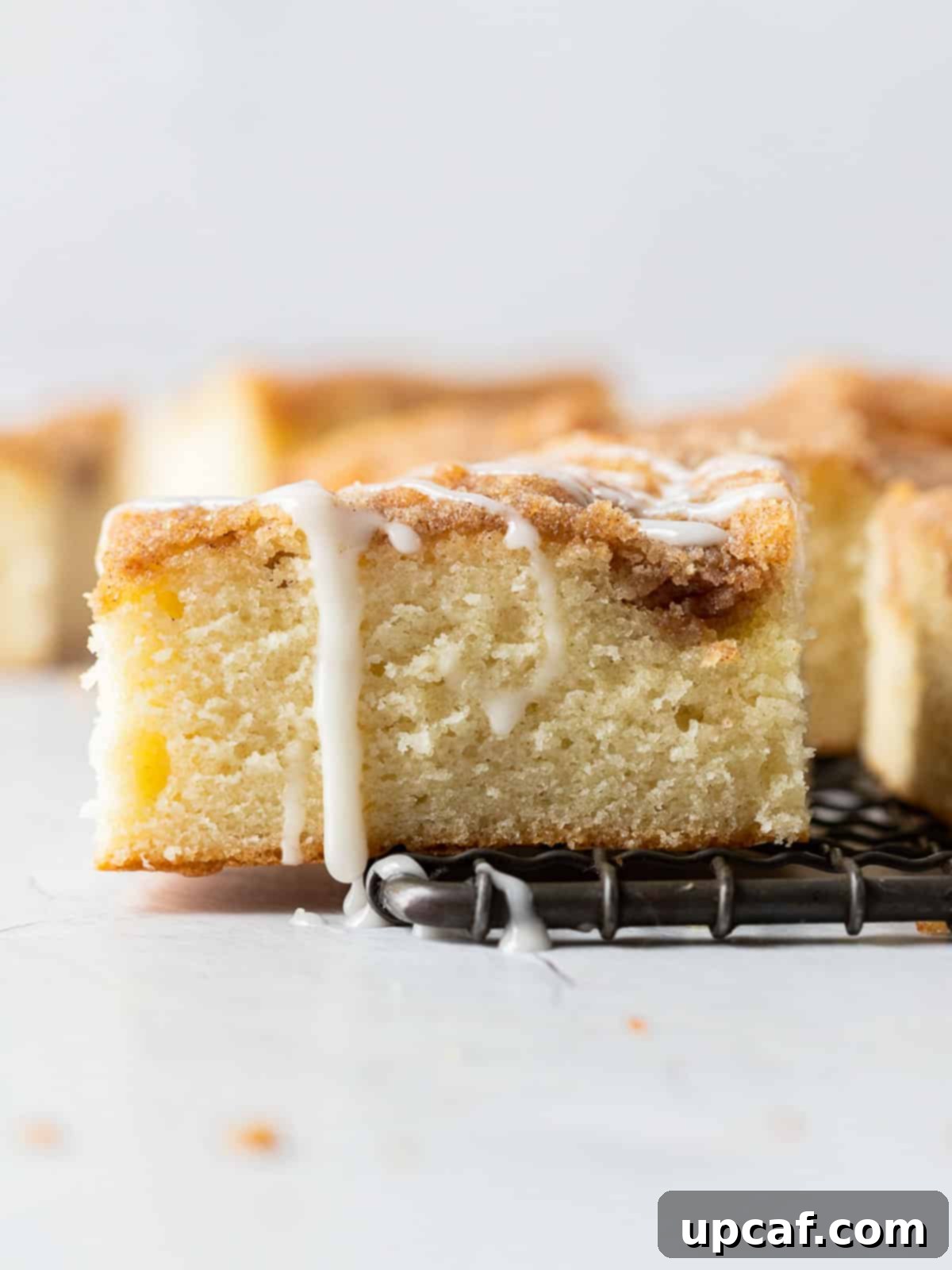 piece of Cinnamon Streusel Cake on a cooling rack with a spoon nearby