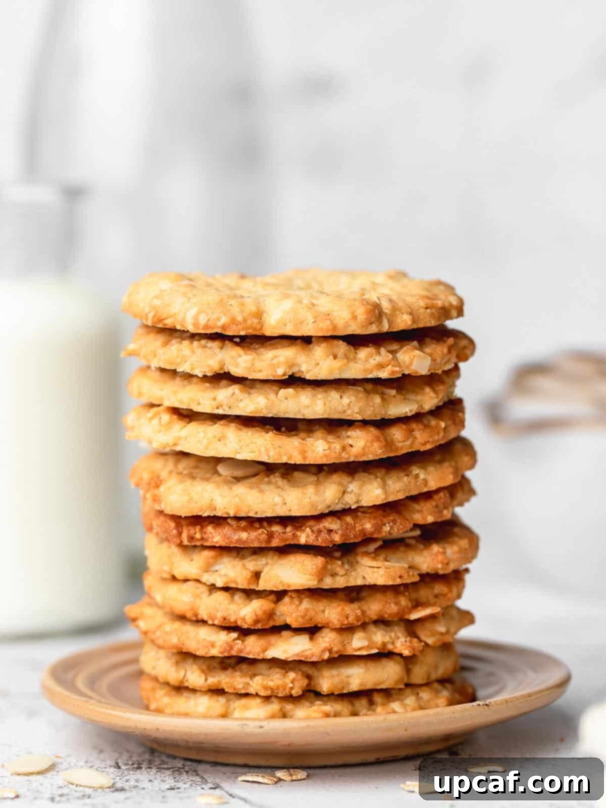 crispy almond oatmeal cookies stacked on a plate