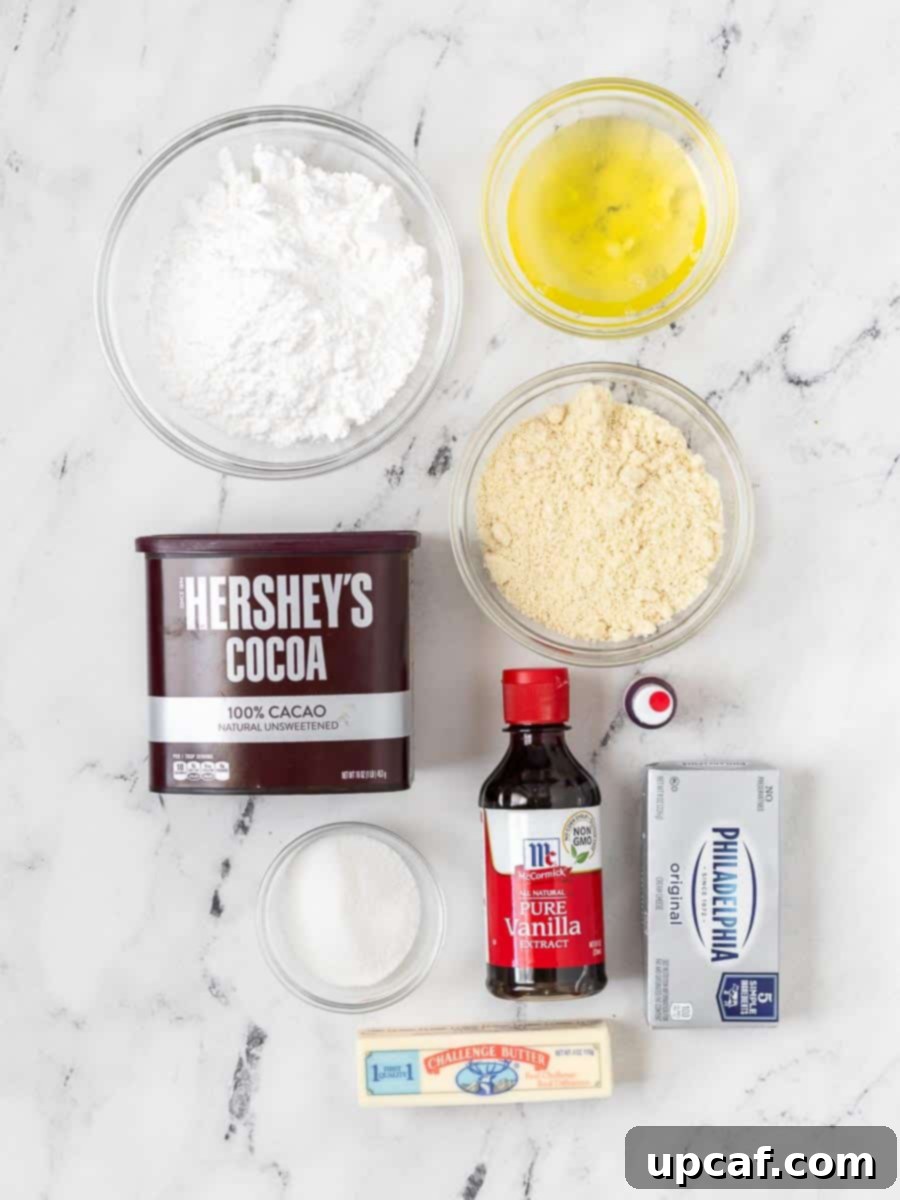 A curated selection of fresh ingredients laid out, including powdered sugar, almond flour, cocoa powder, eggs, granulated sugar, and red food coloring for the macaron shells, ready for preparation.