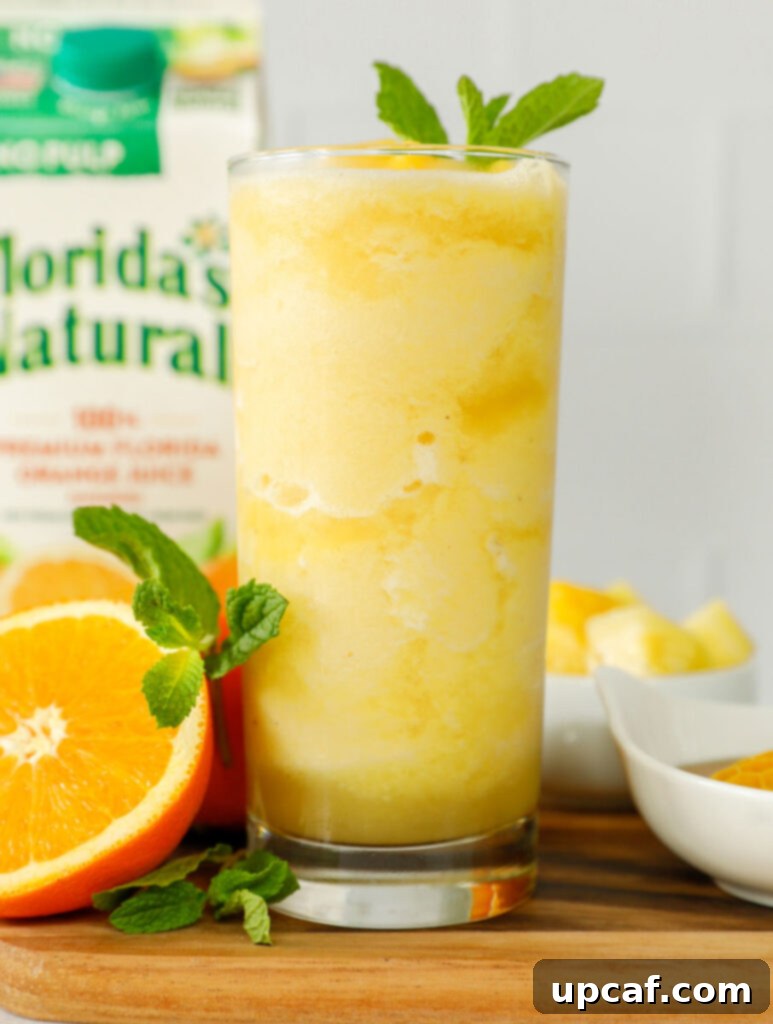 Pineapple slushie in a tall glass.