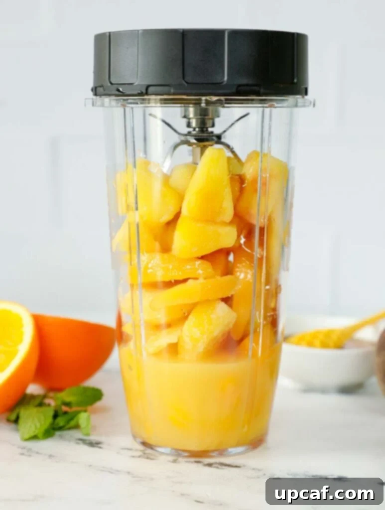 Peach N' Orange slushie ingredients inside of a blender.