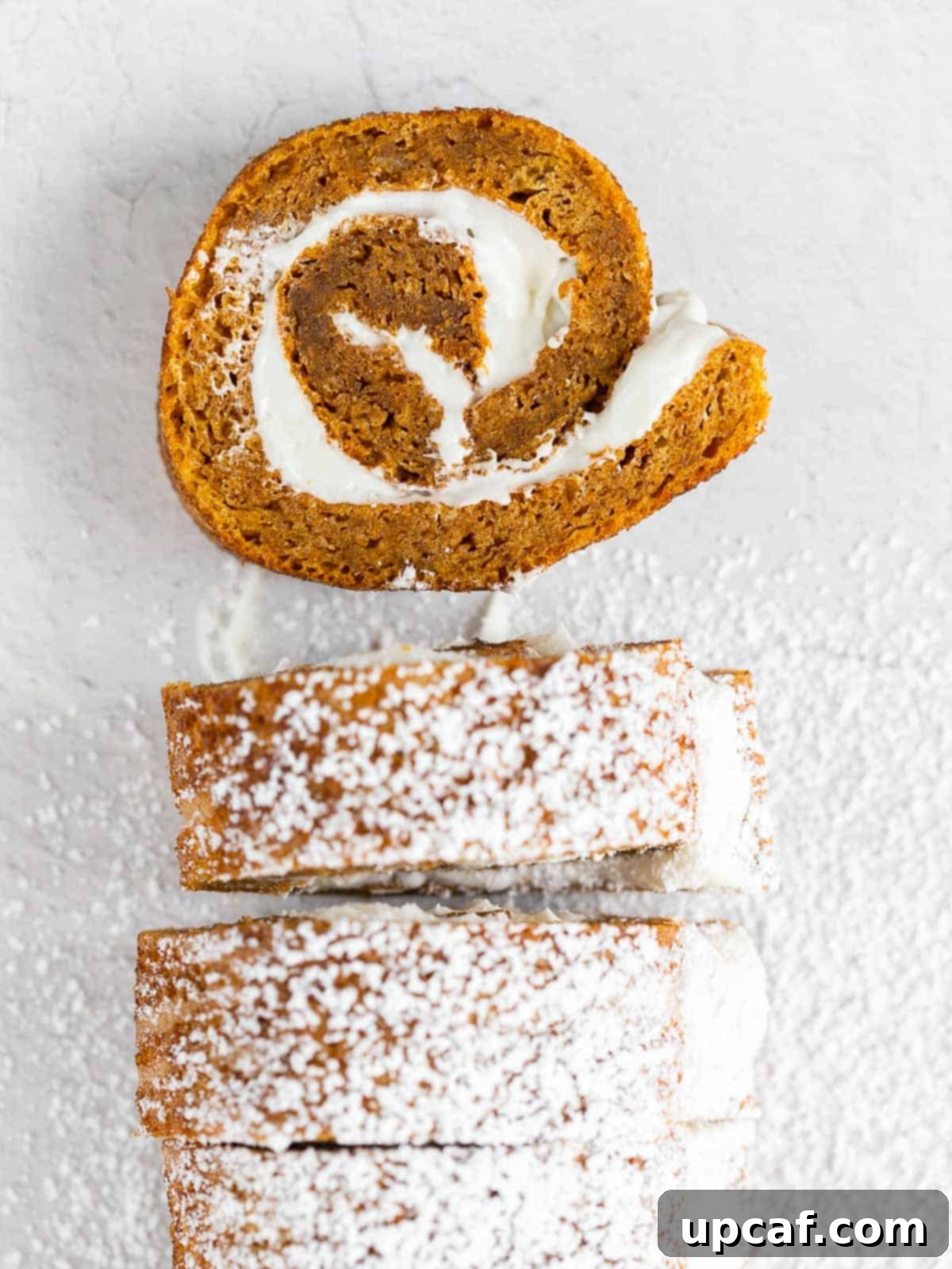 slices of delicious pumpkin cake roll dusted with powdered sugar, ready to be served