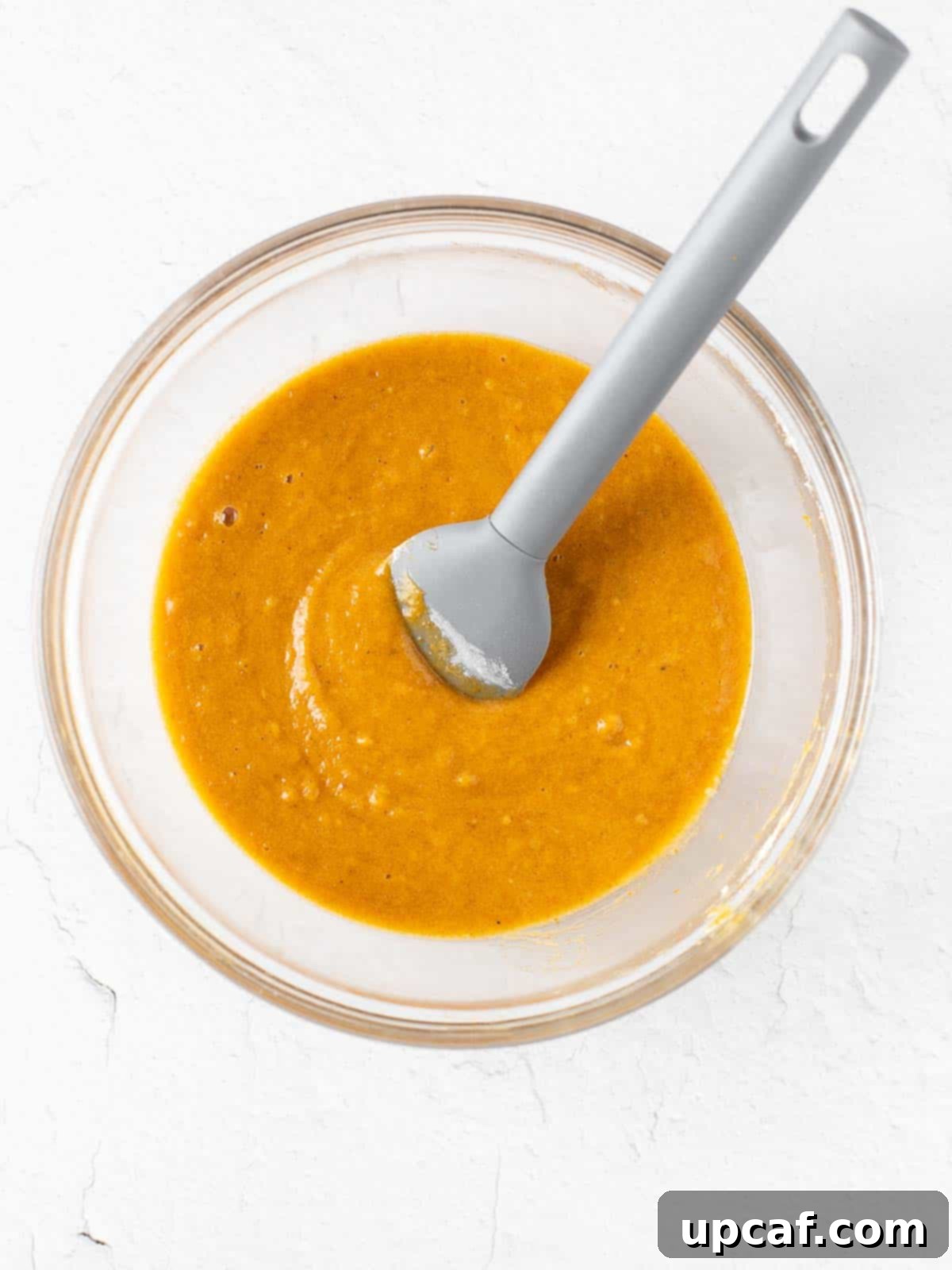smooth, orange-hued pumpkin cake roll batter in a mixing bowl