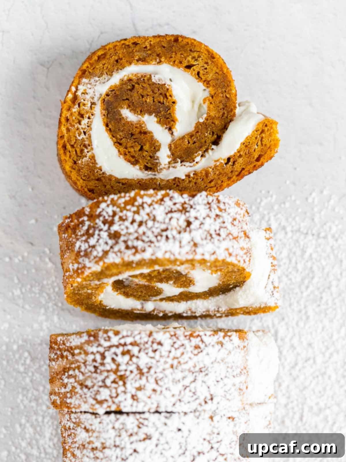 beautifully cut pieces of pumpkin cake roll, lightly dusted with powdered sugar, arranged artfully