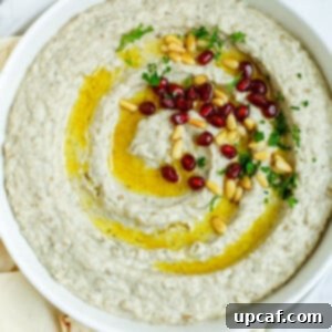 Smoky Lebanese Baba Ganoush 13 baba ghanouj in a plate topped with olive oil, toasted pine nuts and pomegranate seeds