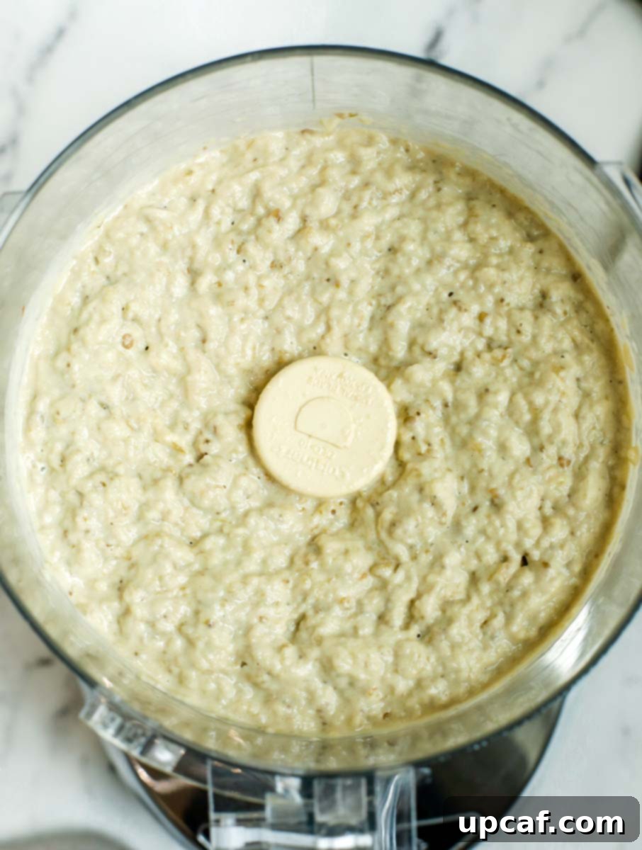 Smoky Lebanese Baba Ganoush 7 A food processor bowl containing the freshly processed Baba Ganoush, showing its characteristic chunky yet creamy texture after being blended.