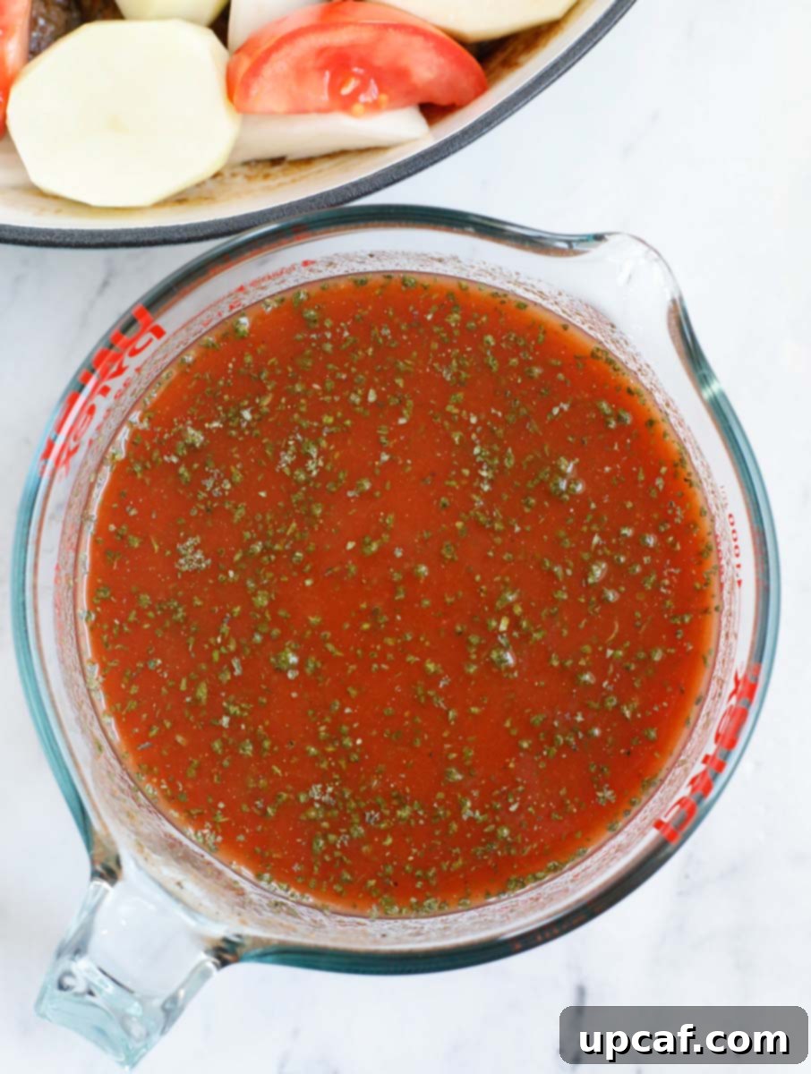 Hearty Kafta and Potato Stew 10 A close-up of a bowl containing the vibrant red sauce ingredients for kafta stew, being whisked together until smooth and well combined.