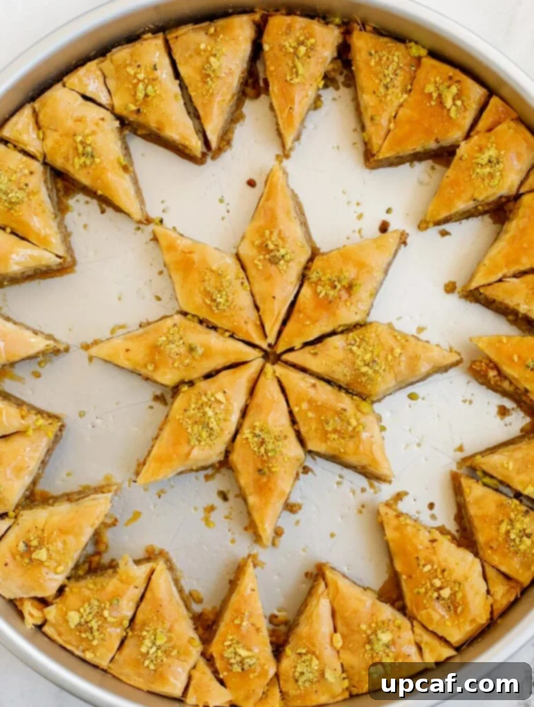 Walnut baklava in a pan with pieces removed.