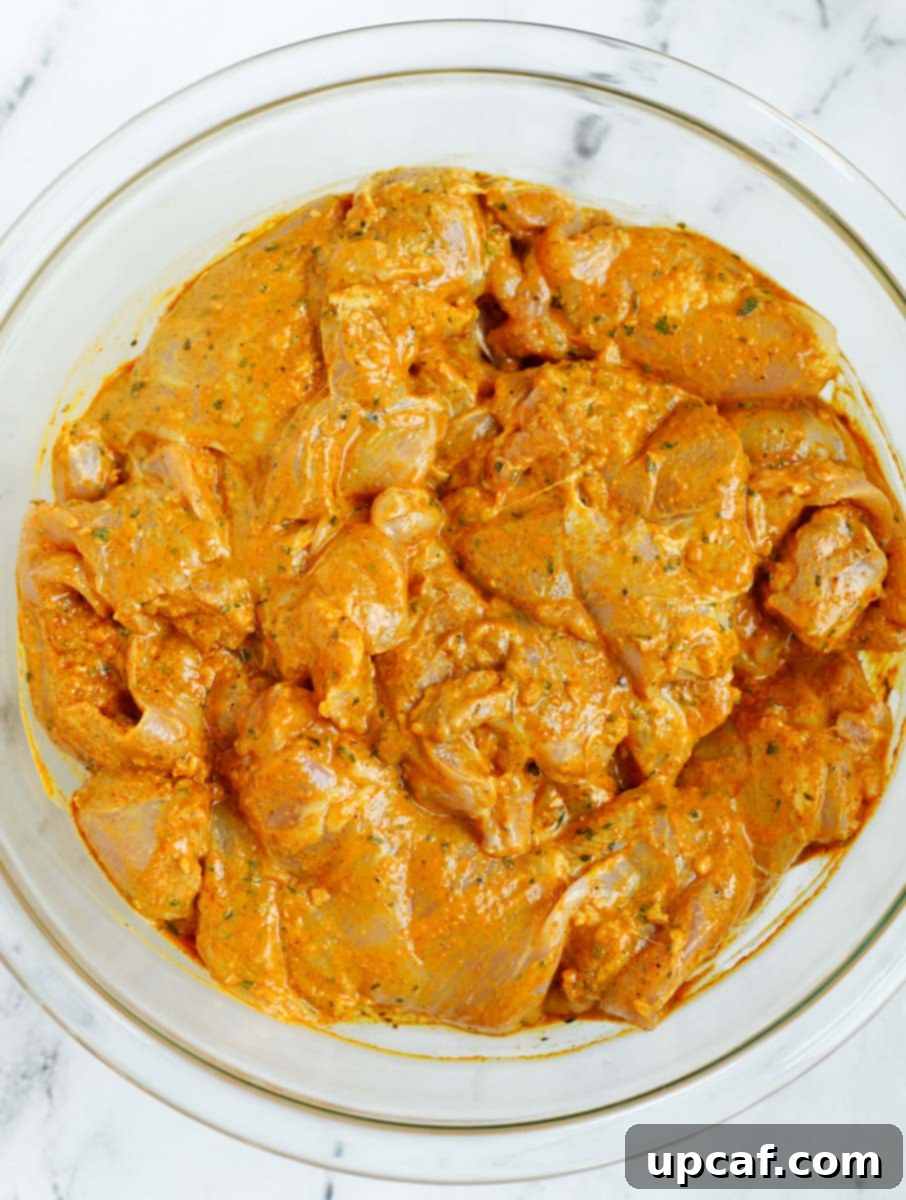 Chicken marinating in a bowl, absorbing all the aromatic spices.