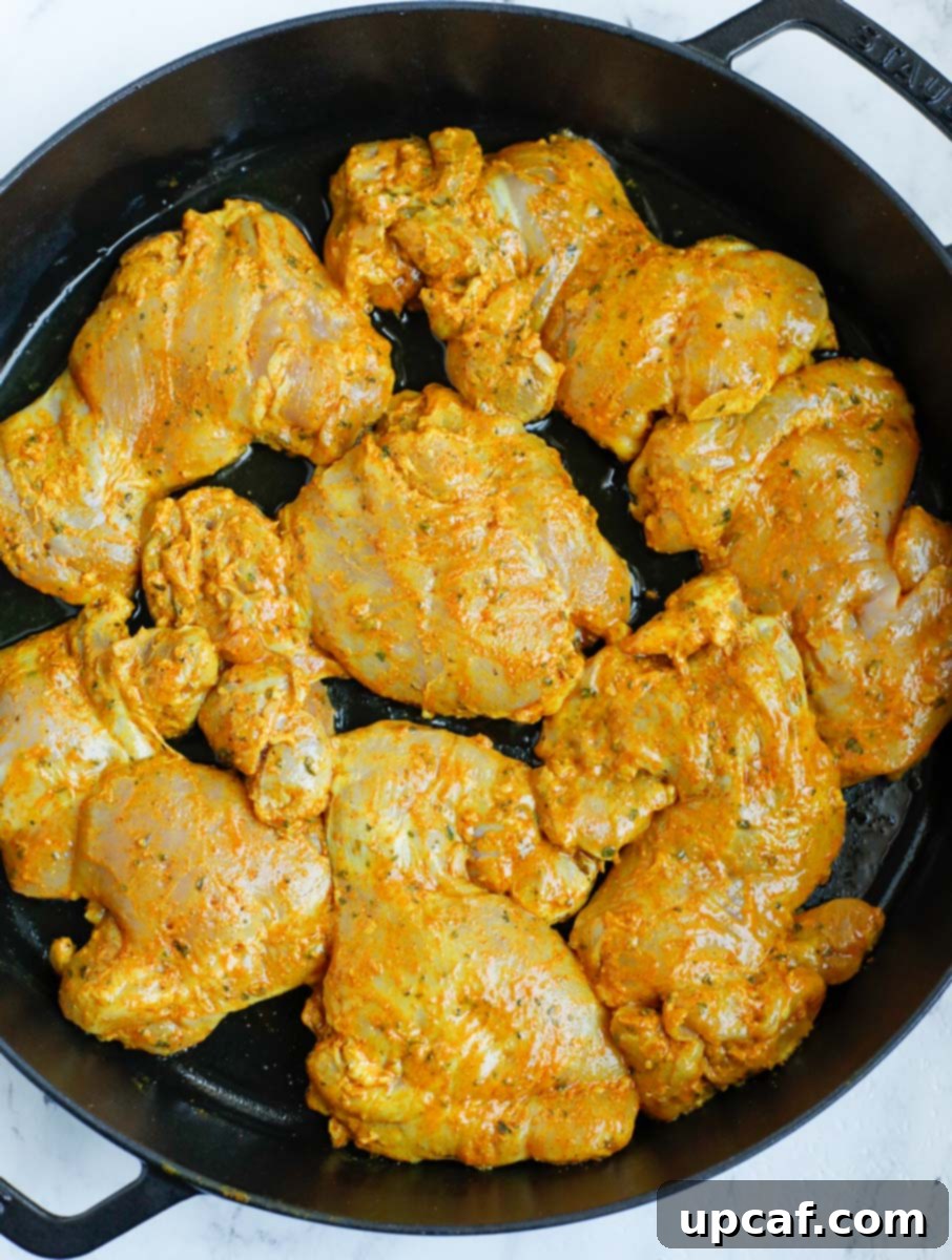 Chicken shawarma in a cast iron before cooking, ready to be seared.