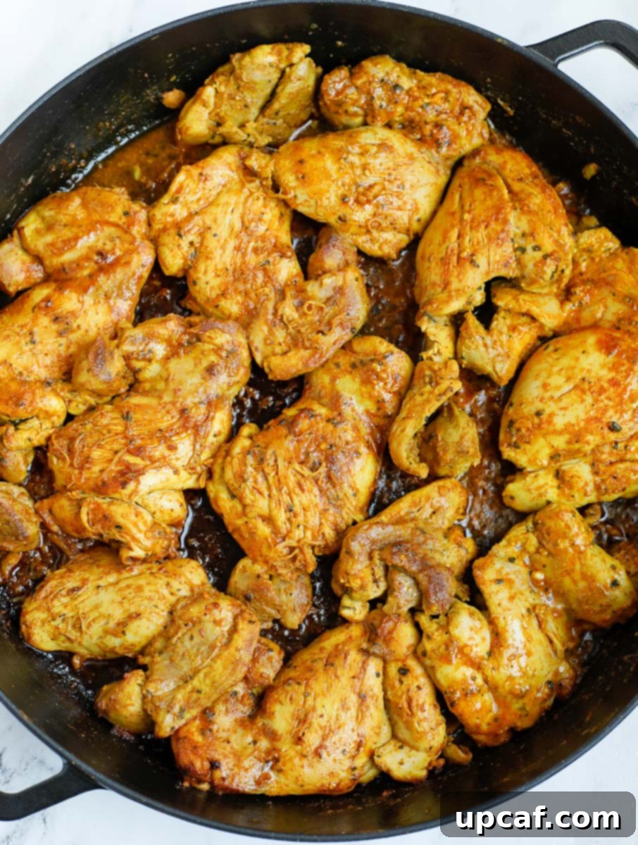 Chicken shawarma being seared in a cast iron after cooking, showing a beautiful crust.