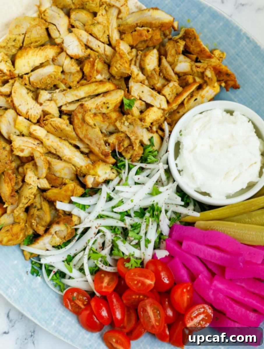 Close up of a platter of chicken shawarma recipe, garnished and ready to serve.