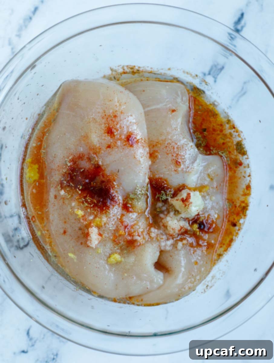 A bowl of chicken breasts with marinate.