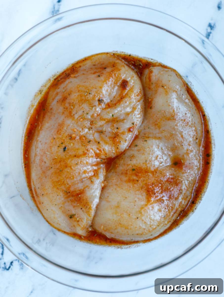 Marinade for rosemary chicken mixed throughly on the raw chicken breasts.